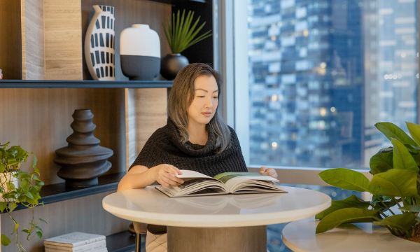 A picture of Gwen our design principal sitting on a table reading a book
