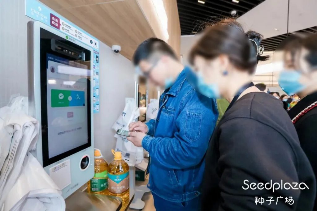 People at a self-service check-out machine