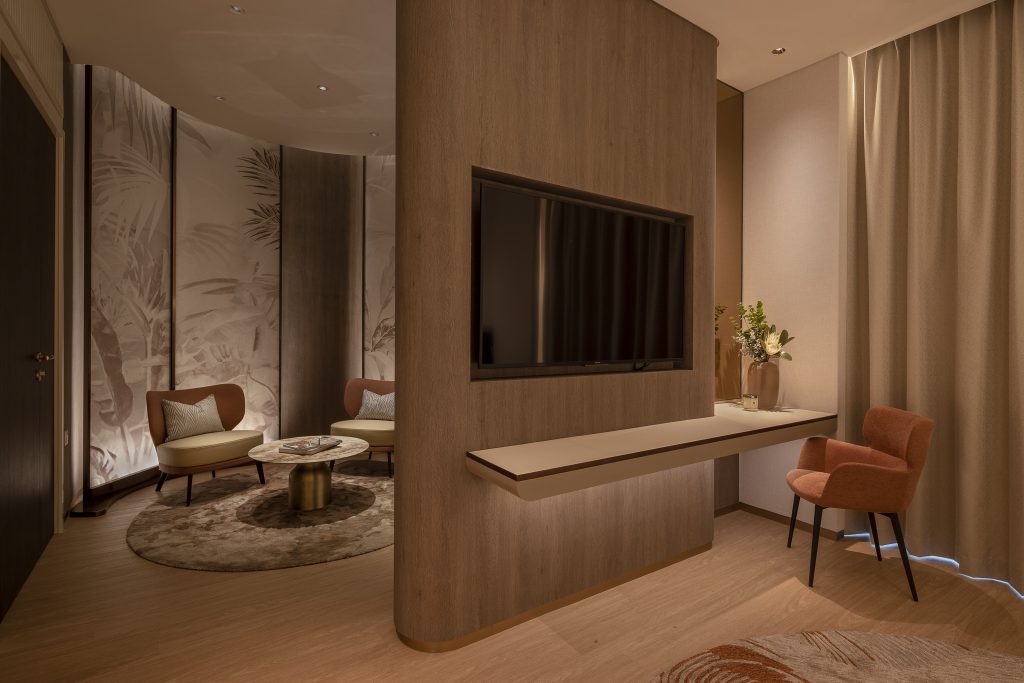 Partition wall with a television on it and a small lounge area